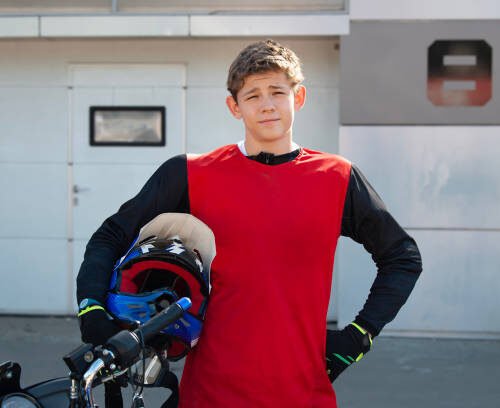 portrait of a racer against the backdrop of a box at a race track.